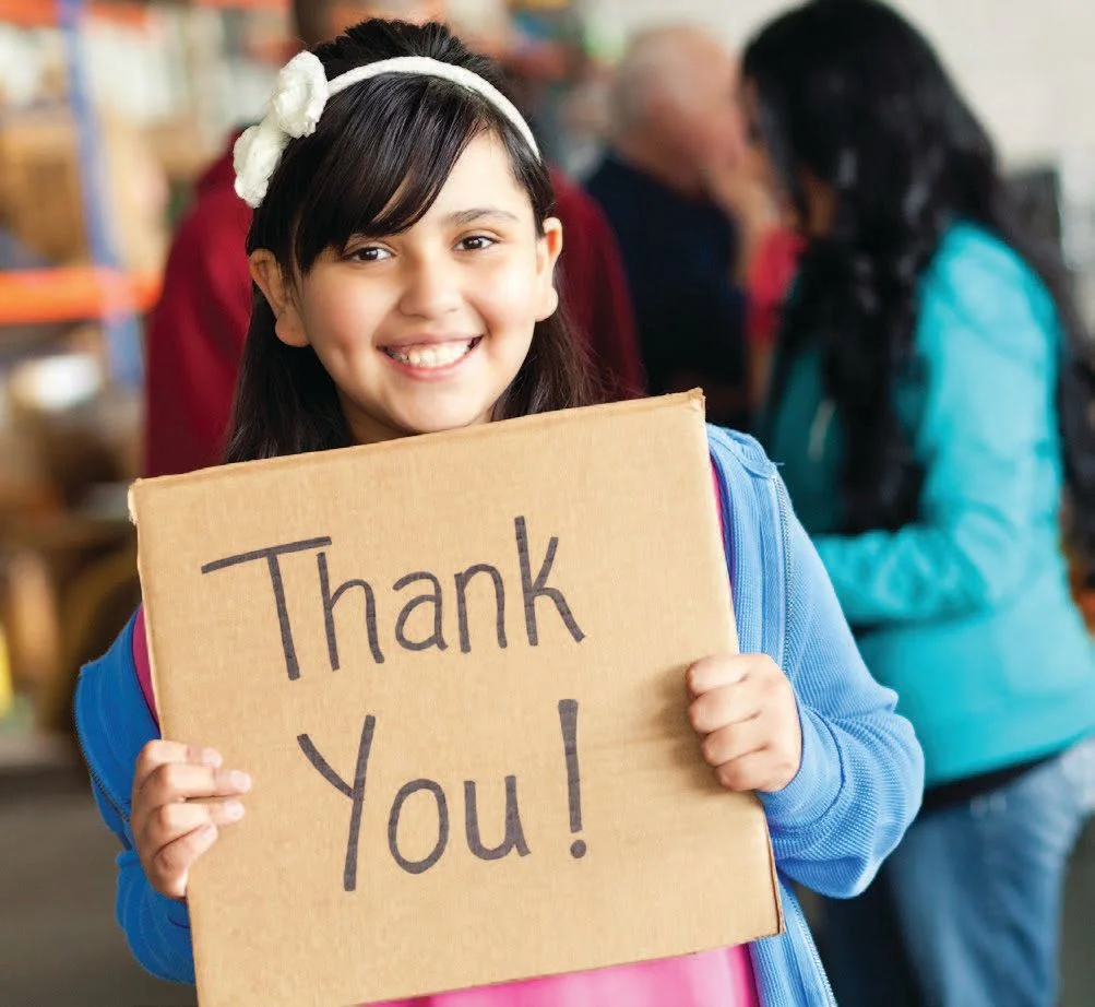 girl holding a thank you sign